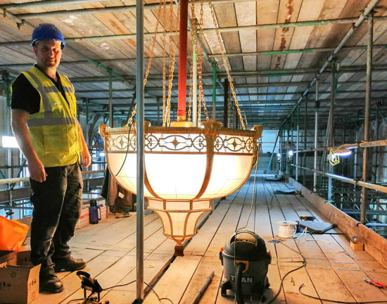 A Fritz Fryer restorer with a chandelier from the Grand Hotel Birmingham